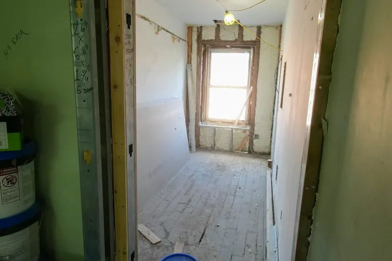 A room under renovation with unfinished floor, walls and door.